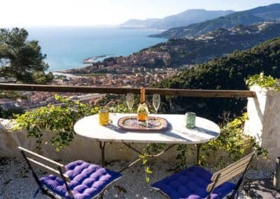 Picture of the Ligurian Sea and Mountains with a table and chairs